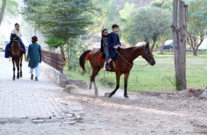 Children enjoy horse riding in National Park.