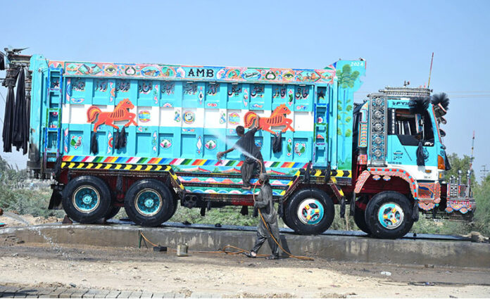 Workers are busy washing the truck at the service station
