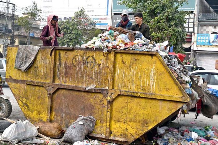 Gypsy youngsters searching and collecting valuables from garbage container at KhannaPul