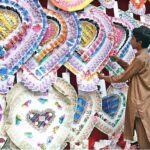 A vendor displaying the garlands of currency notes to attract the customers at his shop