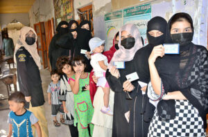 - A woman casting her vote in a polling station during by-election of Local Government UC 51 at Liaqat Colony.