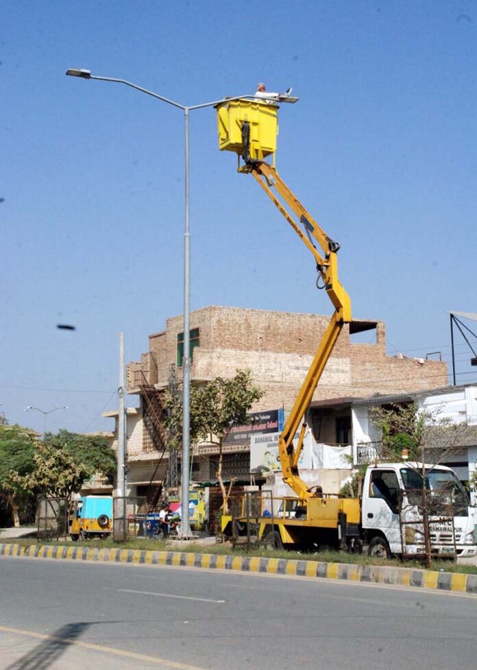 Municipal Corporation workers repairing faulty streetlights to ensure brighter streets