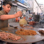 A street vendor preparing beef liver to attract customers at a roadside stall