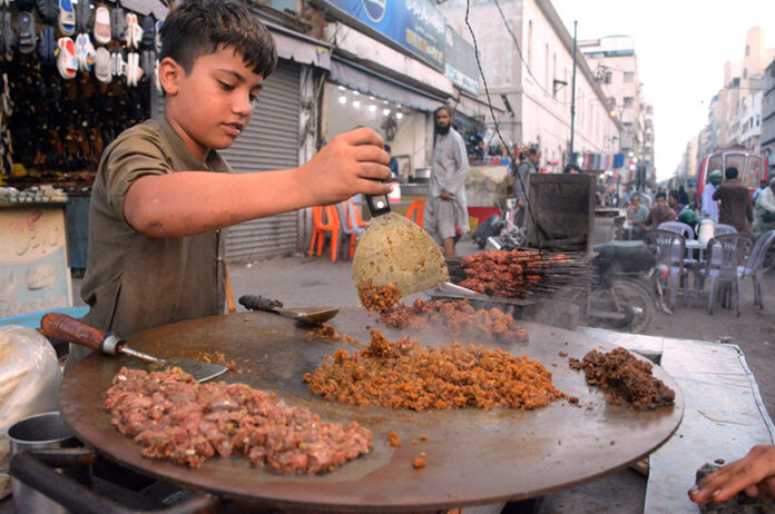 A street vendor preparing beef liver to attract customers at a roadside stall