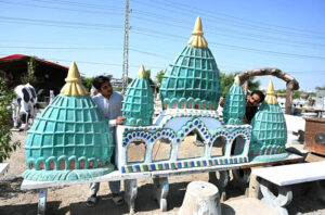 Workers crafting intricate mosque entrance door designs at Eidgah Road.