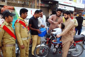 Polio health workers and school scouts administer polio drops to young children at Farid Gate in the city, in efforts to eradicate polio in Pakistan