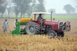Farmers preparing his field with the help of a tractor for the wheat crop.