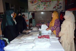 Women exploring the handicraft stalls at the Dastkari Exhibition at Qasr-e-Behbood