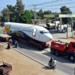 A heavy trailer transports a retired Boeing 737 airplane from Karachi to Hyderabad Airport