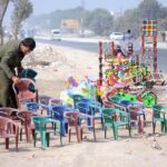 A vendor displaying chairs for children and different items to attract customers at Syed Wala Chowk