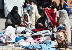 Women busy in selecting and purchasing old warm cloth from vendor during winter season