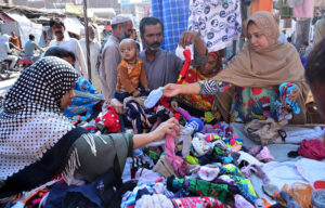 Women busy in selecting and purchasing old warm cloth from vendor during winter season