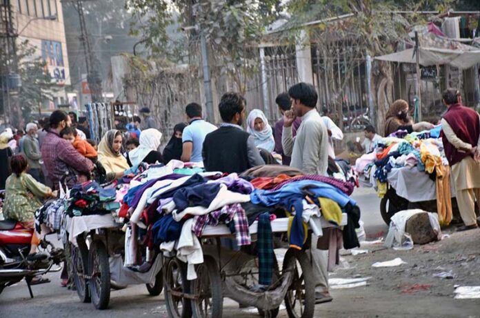 People selecting and purchasing the second hand warm clothes from vendors at Landa Bazaar