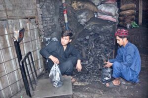 A vendor weighs a coal packet for sale as demand surges with the arrival of the winter season.