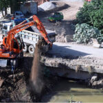 Heavy machinery is being utilized for construction and development tasks during the expansion of the service road in the Federal Capital
