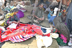 Gypsy women busy sewing blanket outside their temporary hut at Makki shah area.