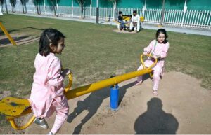 Children are enjoying playing on a seesaw in a local park in the Federal Capital