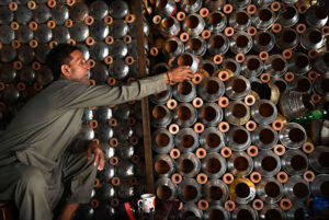 A vendor arranges and displays upper parts of the traditional smoking Hookah (chilam) at his shop in the provincial capital