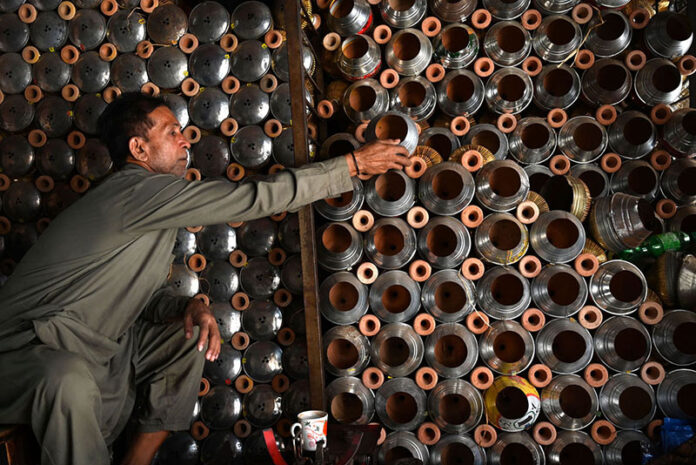 A vendor arranges and displays upper parts of the traditional smoking Hookah (chilam) at his shop in the provincial capital