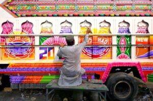 A painter is engaged in truck art in the body of a truck at his workplace in the Ring Road area.