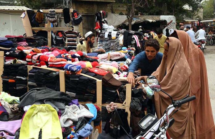 A vendor sells warm caps, socks for children on his handcart at Church Road, attracting customers as the temperature gradually drops in the city