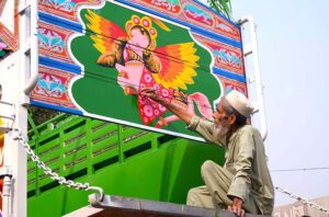 A painter is engaged in truck art in the body of a truck at his workplace in the Ring Road area.