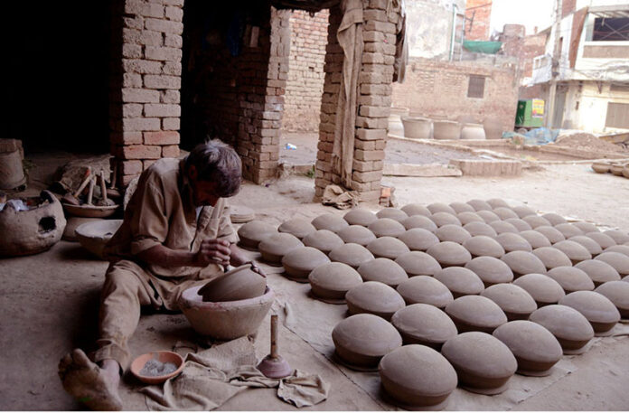 A worker busy in preparing clay made pots at his workplace in Provincial Capital