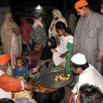 Deserving individuals stand in a queue in front of the langar khana to receive free food at Mauj Darya Road