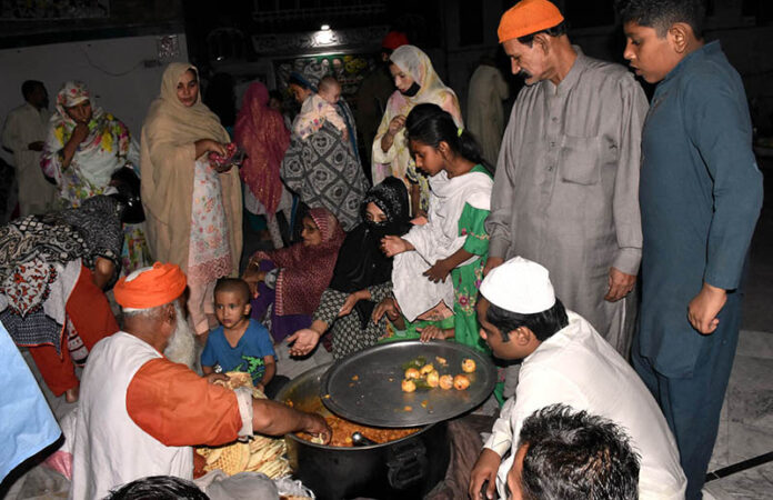Deserving individuals stand in a queue in front of the langar khana to receive free food at Mauj Darya Road