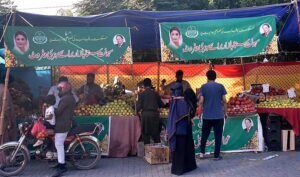 People buying fruits from stalls at Sahulat Sasta Bazar, organized by the Punjab government