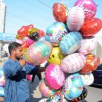 A street vendor sells colorful balloons to attract customers in the Clifton area