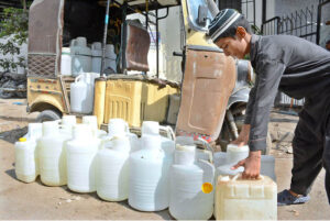 Youngster loading water cane on Rickshaw after filling from government RO plant at Kalapul.