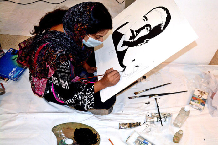 A student gives final touch to the portrait of Allama Muhammad Iqbal on his 147th Birth Anniversary organised by Knowledge Academy ofArts