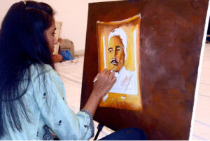 A student gives final touch to the portrait of Allama Muhammad Iqbal on his 147th Birth Anniversary organised by Knowledge Academy ofArts