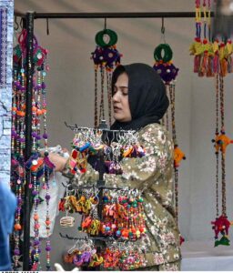 Women visitors express their interest in the beautiful crafted brass items displayed at a handicraft stall during Lok Mela, the Folk Festival at Lok Virsa in federal capital.
