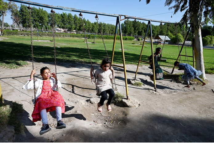 Children enjoy swing at Rani Bagh to spend their holiday on the eve of the birth anniversary of the national poet Allam Muhammad Iqbal