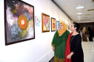 Art lovers admire a calligraphy exhibition by Tauseef Ahmad Tauseefi, organized by the Arts Council