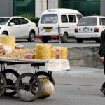 A hawker pushes his handcart on the Blue Area's street in Federal capital, selling snacks and dry fruits to support his family