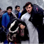 A street vendor sells winter jackets to customers, as demand rises with the dropping temperatures in the provincial capital, while shuttling on the road to earn a livelihood