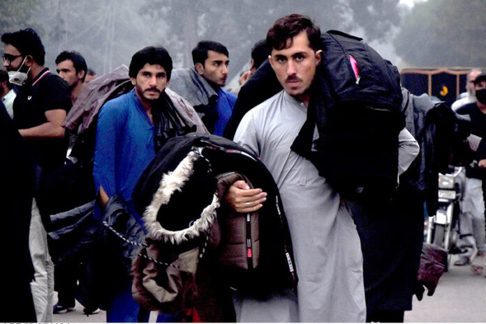 A street vendor sells winter jackets to customers, as demand rises with the dropping temperatures in the provincial capital, while shuttling on the road to earn a livelihood