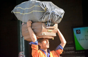 Porters at Cantt Railway Station skillfully balancing luggage as they navigate the busy platforms.