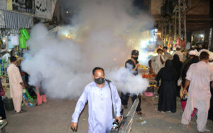 A health worker sprays anti-dengue spray across the city to control the disease as dengue fever cases rise.