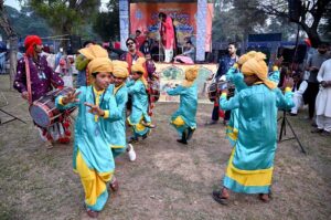 A drumbeater plays while spinning heavy hanging drums around him during the opening ceremony of the 'Annual Ten-Day Folk Festival Lok Mela' at Lok Virsa in the federal capital