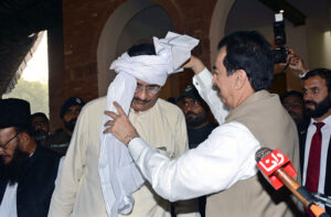 Chairman Senate/Caretaker President, Syed Yusuf Raza Gilani, ties a turban (Dastarbandi) to MNA Raza Hayyat Hiraj after offering condolences on the death of his father, Khizar Hayyat Hiraj, at Choki Hiraj, Kabirwala.
