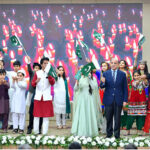 Prime Minister Muhammad Shehbaz Sharif waving the Pakistani Flag at a ceremony to celebrate Allama Muhammad Iqbal's Birthday