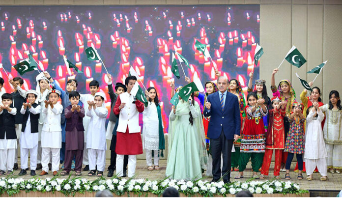Prime Minister Muhammad Shehbaz Sharif waving the Pakistani Flag at a ceremony to celebrate Allama Muhammad Iqbal's Birthday