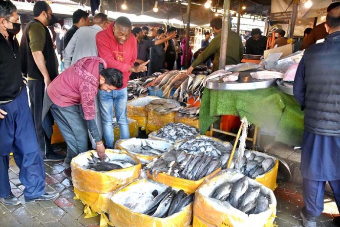 People busy purchasing fish from vendor at Sunday Bazaar, Peshawar Morr