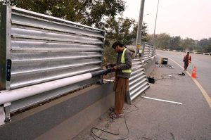 A welder busy reinforcing the roadside fence on Zero Point Flyover in the Federal Capital