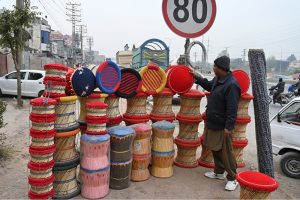 A vendor displays hand-made Traditional Chairs (Morras) at his roadside setup to attract the customers