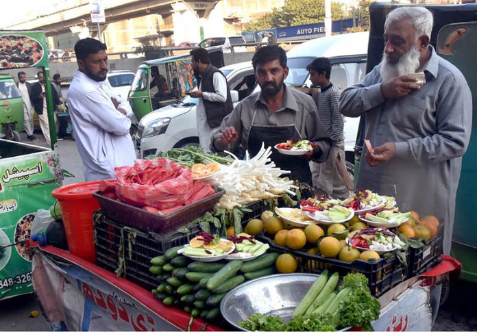 A vendor selling fresh salad at muree raod in the city